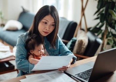 Young mother with baby daughter working from home